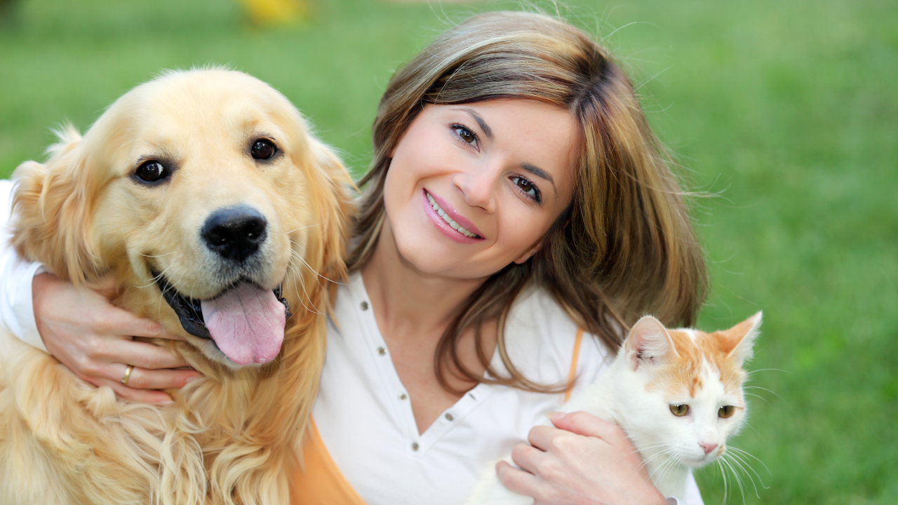 Hund_Katze_Versichert Eine Tierbesitzerin ist glücklich, nachdem sie eine digitale Versicherung für ihren Hund und ihre Katze abgeschlossen hat.