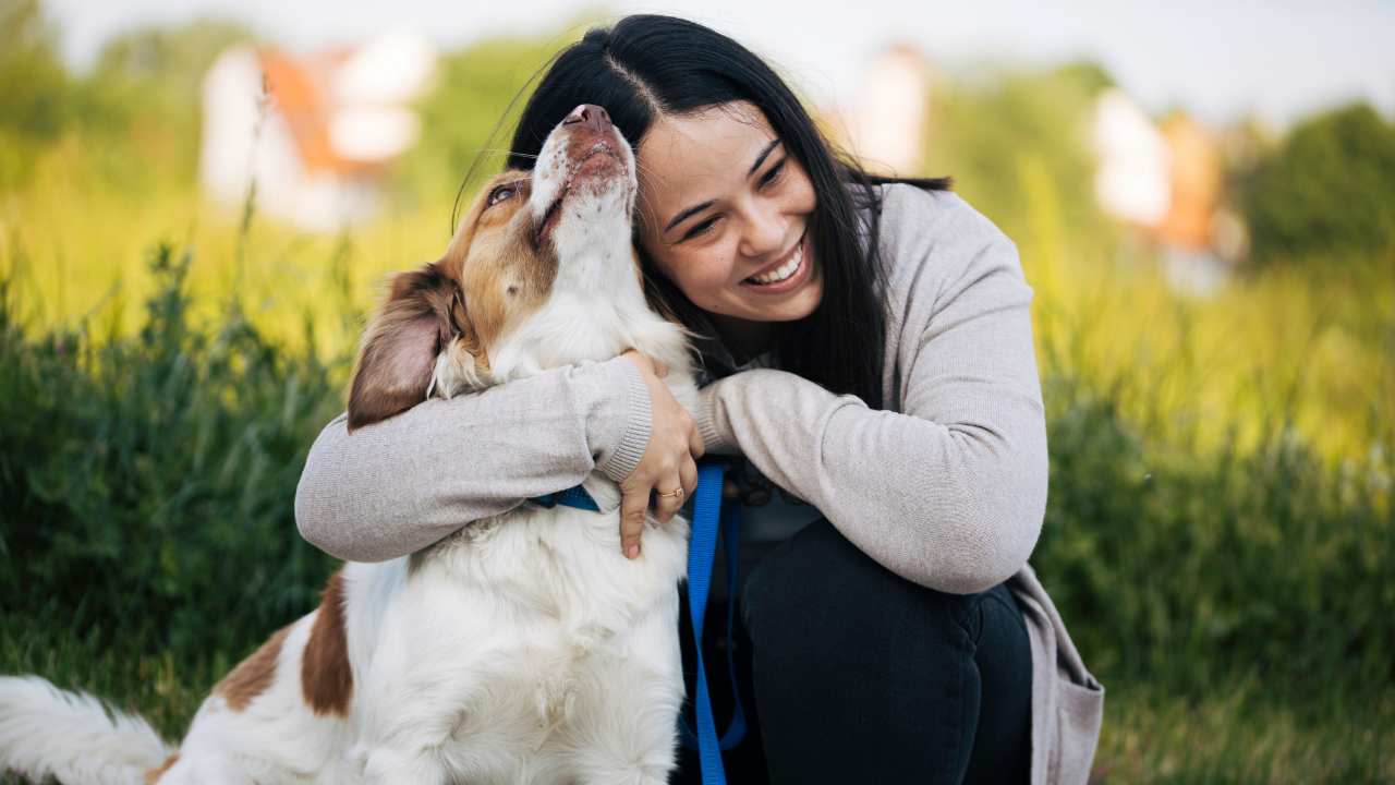 2_hypoallergene_Hunde Eine Frau kuschelt mit ihrem hypoallergenen Hund in der Natur.