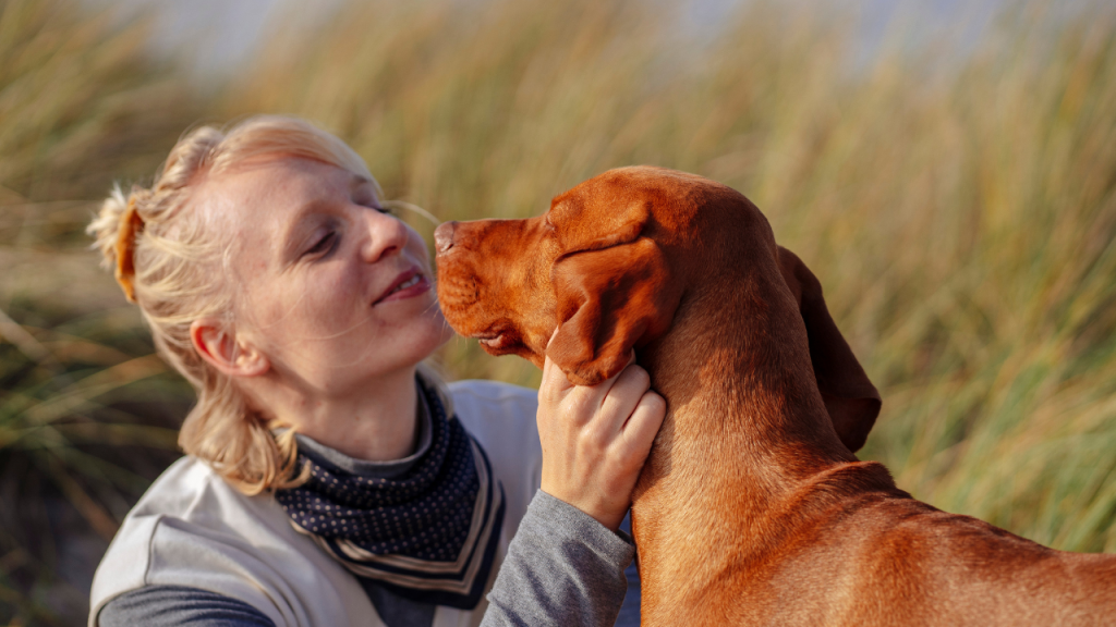 Eine Frau schaut ihren Hund mit liebevollen Blicken an.